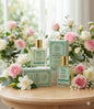 Two bottles and two boxes of 'Floral Romance Luxury' perfume on a wooden table with flowers in the background. Red Vocal Floral Romance Luxury Premium Perfume Eau De Toilette – Women’s 100ml Elegant & Long-Lasting Set of 2 Fragrance